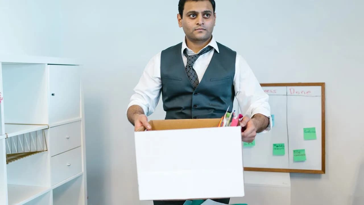 Mann packt Büroutensilien in einen Karton für den Firmenumzug